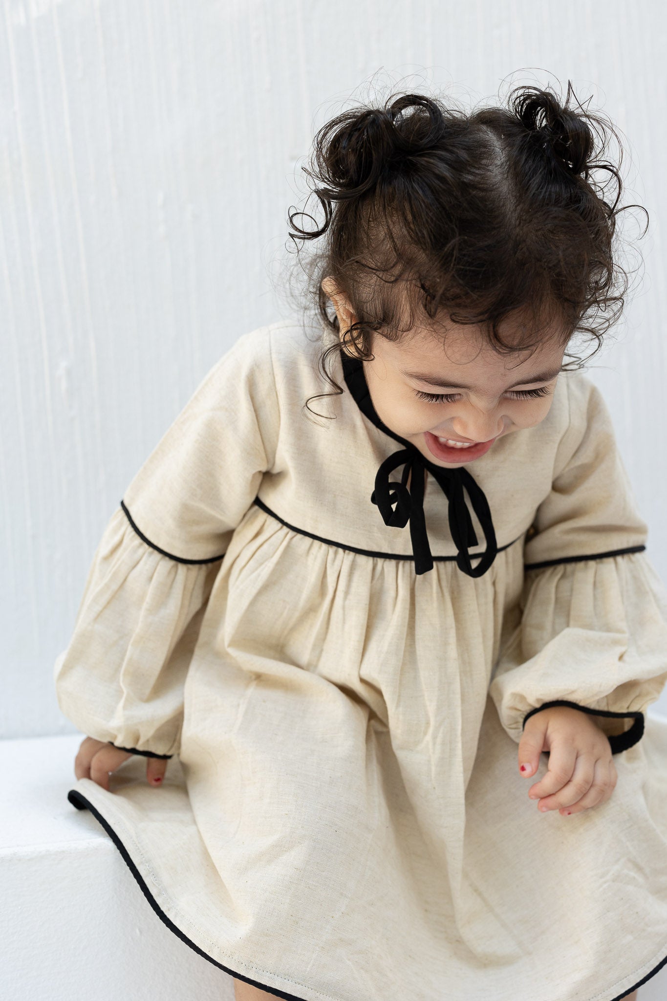 Eclipse Cream Baby Dress with Black Trim and Bow Detail