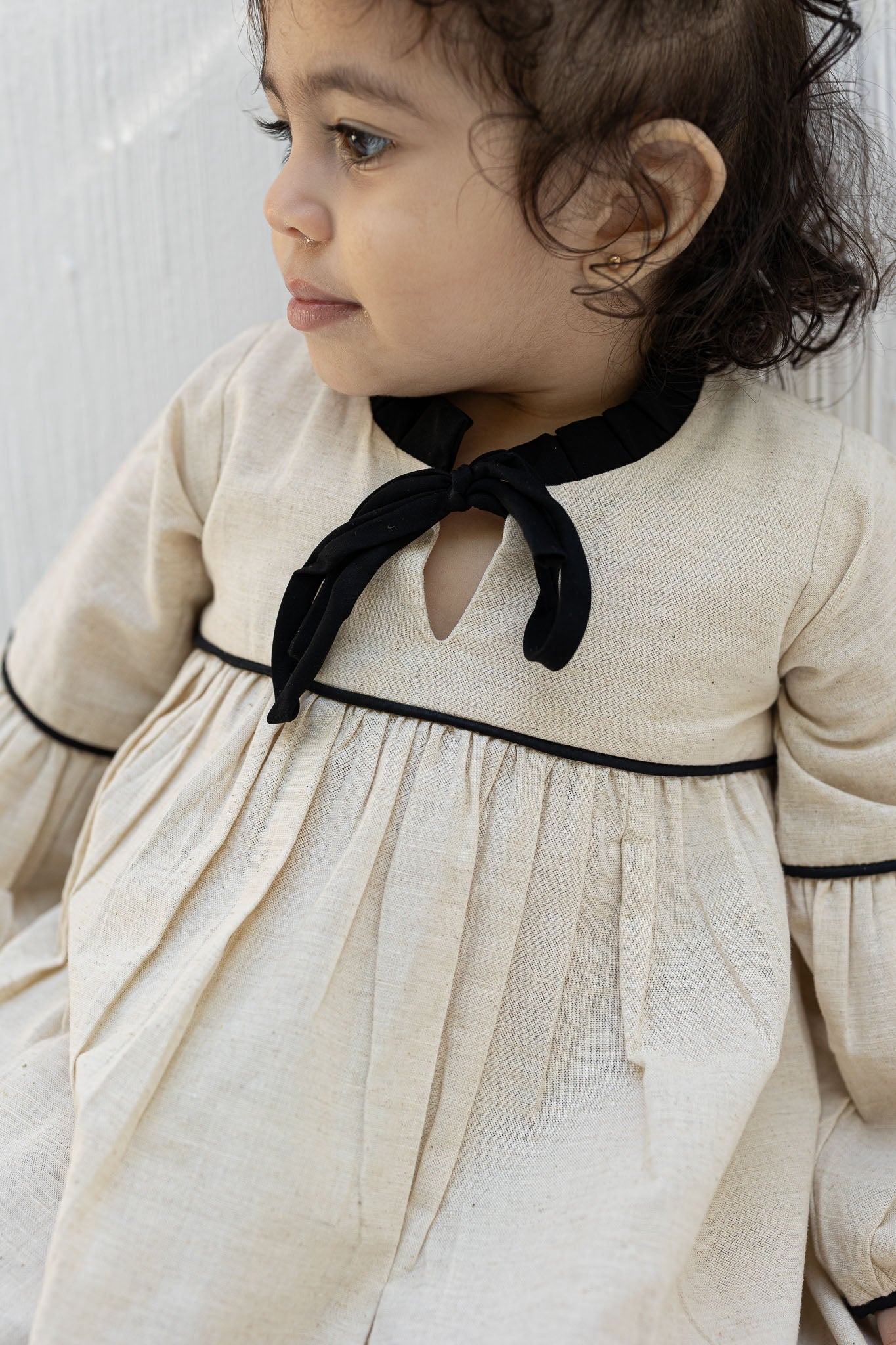 Eclipse Cream Baby Dress with Black Trim and Bow Detail