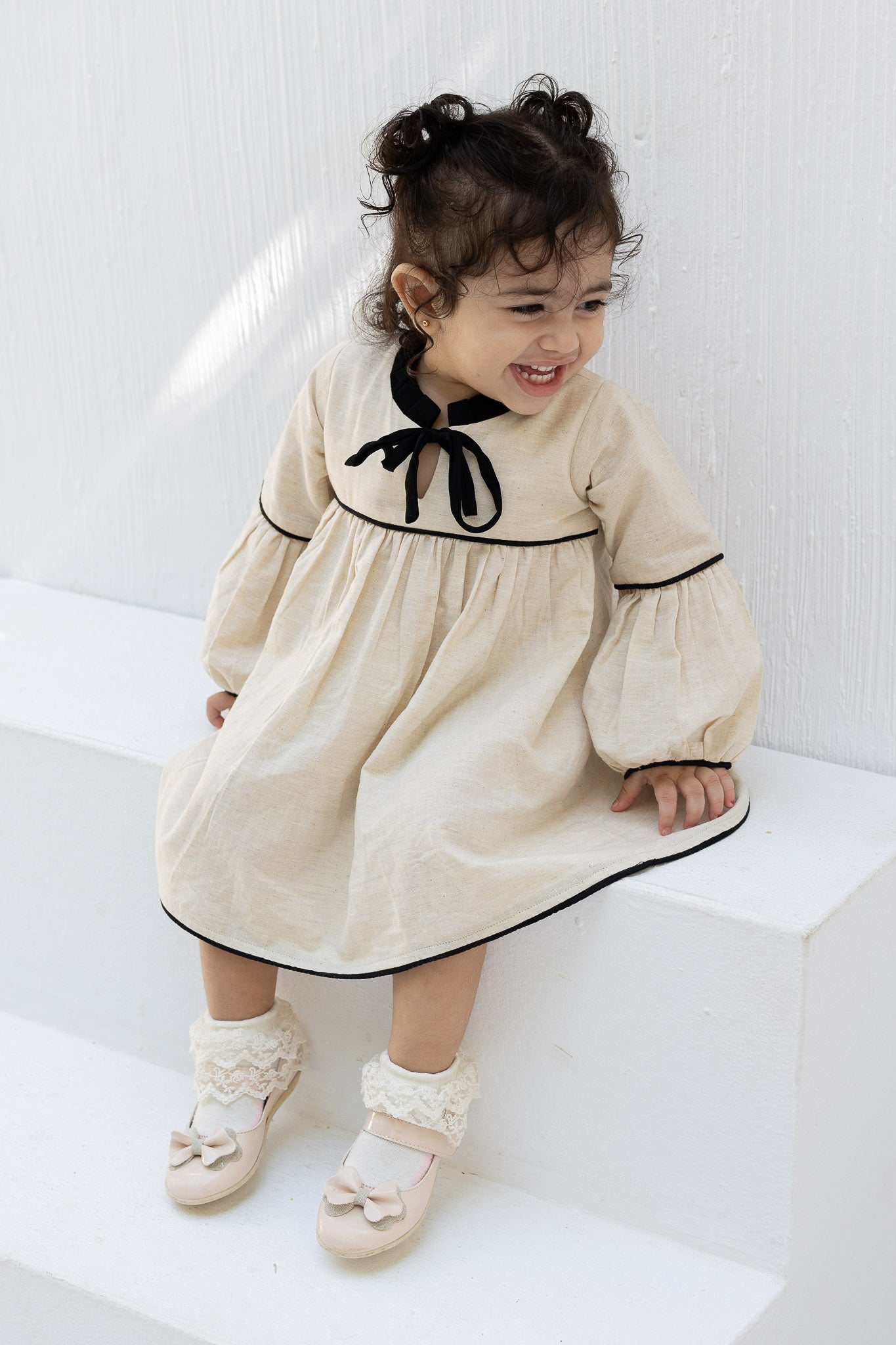 Eclipse Cream Baby Dress with Black Trim and Bow Detail